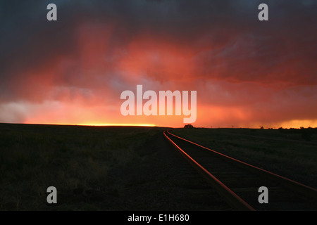 Intensive Sonnenuntergang Farben erhellen die Gleise über diesen Remotestandort, Burlington, Colorado, USA Stockfoto