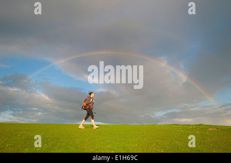 Junge weibliche Wanderer, Wandern unter Regenbogen Stockfoto