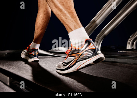 Nahaufnahme eines männlichen Beine auf Fitness Laufband in Höhe Mitte Stockfoto