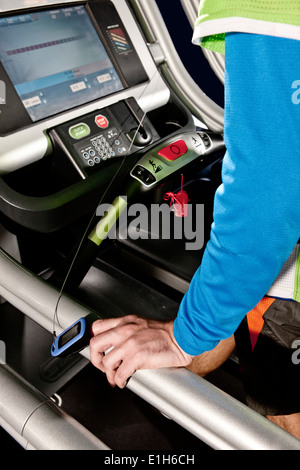 Nahaufnahme eines männlichen Arm und Pulsmesser auf Fitness-Studio-Laufband in Höhe Mitte Stockfoto