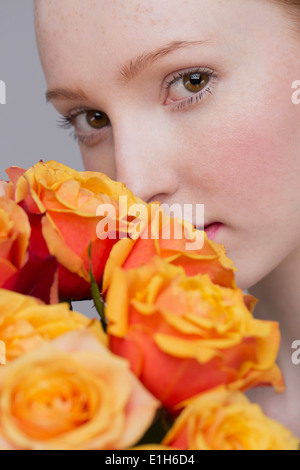 Porträt der jungen Frau, hält Rosenstrauss Stockfoto