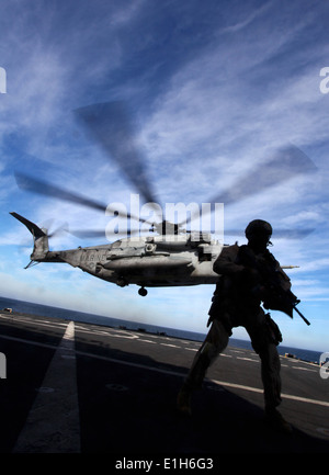 USNS Arktis - eine Marine mit der 24. Marine Expeditionary Unit Force Reconnaissance Platoon, sorgen für Sicherheit während einer CH-53E Stockfoto