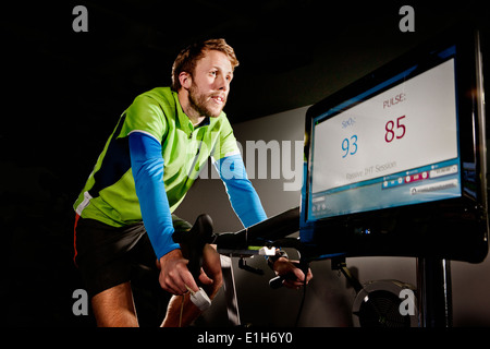 Junger Mann auf Fitness-Studio trainieren Zyklus in Höhe Mitte Stockfoto