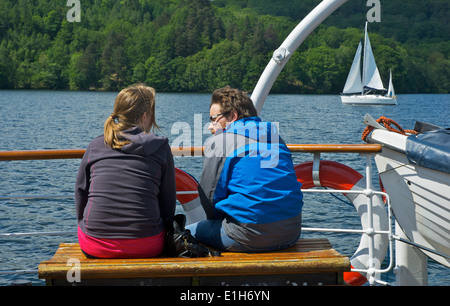 Junges Paar entspannen Sie sich auf "Dampfer", Lake Windermere, Lake District National Park, Cumbria, England UK Stockfoto