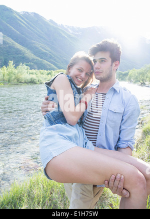 Junger Mann mit Freundin in Armen am Toce Ufer, Piemont, Italien Stockfoto