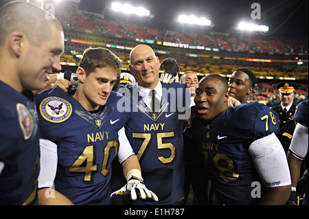 US Army Chief Of Staff General Raymond T. Odierno dons ein Navy Fußballtrikot und Pose für ein Foto mit Navy Midshipmen achtern Stockfoto