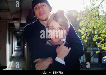 Junges Paar mit Arm herum, im Wohnblock, London, UK Stockfoto