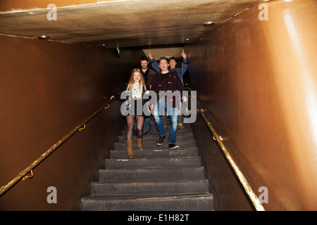 Gruppe der Freunde, die Treppe hinunter in Nachtclub Stockfoto