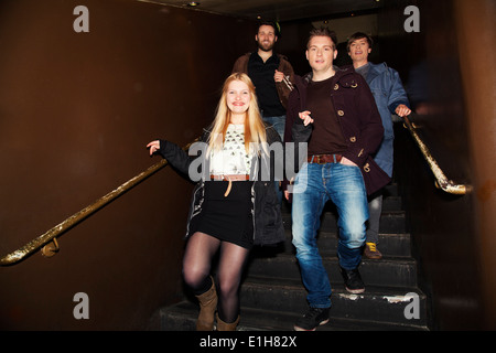 Freunde, die Treppe hinunter in Nachtclub Stockfoto