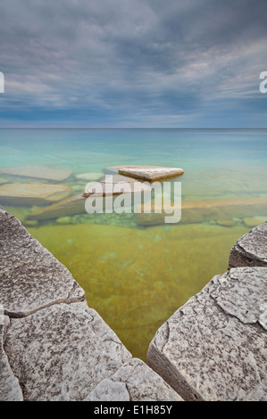 Interessante Felsformationen und kristallklarem Wasser mit einer eingehenden Sturm. Bruce Peninsula National Park, Ontario, Kanada. Stockfoto