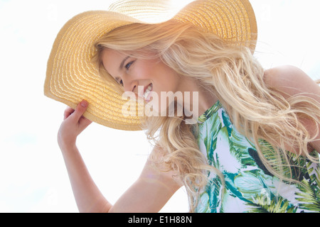 Porträt der jungen Frau Sonnenhut festhalten Stockfoto