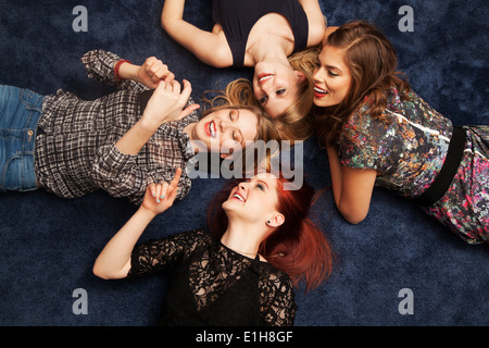 Gruppe von Freunden auf Teppichboden liegend Stockfoto