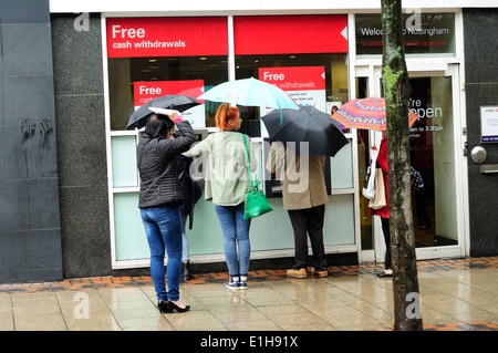 Nottingham, 4. Juni 2014. Menschen, die Warteschlangen an der Kasse im Regen. Stockfoto