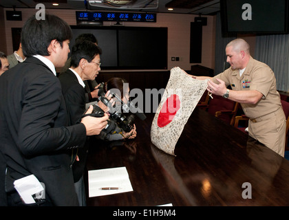 US Navy Lt. j.g. Michael Reid, rechts, Commander US Naval Forces Japan zugeordnet, zentrale Reserve Komponente, enthüllt Stockfoto