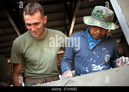 Manat Jeewoinbhlom, links, einem lokalen Freiwilligen und U.S. Marine Corps Lance Cpl. Michael Masontait, rechts, mit Marine Wing Suppor Stockfoto