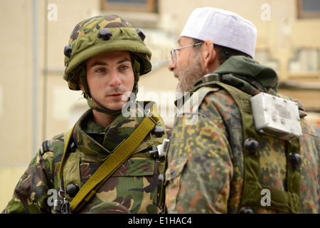 Ein rumänischer Soldat, links, redet mit einem Zivilisten auf dem Schlachtfeld an der Joint Multinational Readiness Center in Hohenfels, Ge Stockfoto