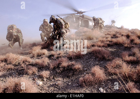 US Special Operations Personal gehen Sie in Deckung zu vermeiden, fliegende Trümmer bei ihrer Vorbereitung auf ein UH-60 Black Hawk Hubschrauber Duri an Bord Stockfoto