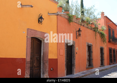 Bunte Häuser entlang der gepflasterten Straße in San Miguel de Allende, Guanajuato, Mexiko Stockfoto