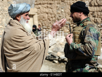 Ein Kommando Afghan National Army (ANA), rechts führt ein Schlüssel Führer-Engagement mit einem afghanischen Dorfälteste während einer Mission ich Stockfoto