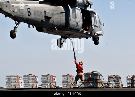 U.S. Navy Lt. Brian Helman reicht einen Ladung Haken ein Besatzungsmitglied an Bord einen MH-60 s Knighthawk Hubschrauber, Hubschrauber Sea Co zugewiesen Stockfoto