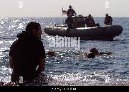 Ein Schwimmer Sicherheit an Bord der USS New Orleans liegt am Heck des Schiffes Tor und wacht über Marines und Matrosen während der Freizeit Stockfoto