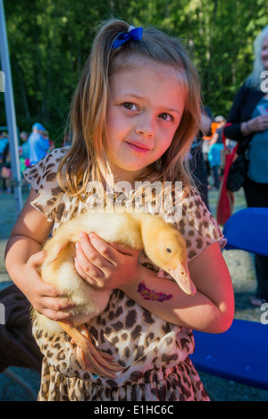 Junges Mädchen hält Baby Entchen auf Frühjahrsmesse, Stockfoto