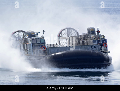 Ein US-Marine Corps Landungsboote Luftkissen (STERNS) nähert sich nun Deck die amphibischen Transportschiff der Dock USS New Yor Stockfoto