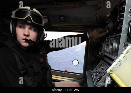US Naval Air Crewman 3. Klasse Benjamin Mosley, mit Hubschrauber Anti-Submarine Squadron (HS) 5, betreibt ein Sonar-Gerät auf einer Stockfoto