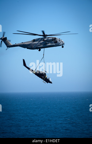 Ein US-Marinekorps CH-53E Super Stallion-Hubschrauber zugewiesen, Marine Medium Helicopter Squadron (HMM) 364 transportiert ein AH-1 Stockfoto