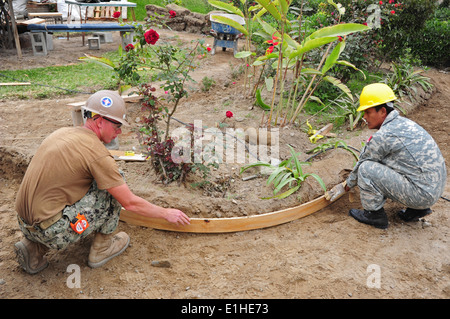 US-Segler und peruanische Soldaten bauen einen Gehweg für eine neue Notaufnahme in Independencia, Peru, 10. Juli 2012, während New Stockfoto