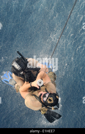 Zwei US-Air Force Pararescuemen mit der 82nd Expeditionary Rescue Squadron (ERQS) sind an Bord eines spanischen Marine SH-60 b Se gehisst Stockfoto