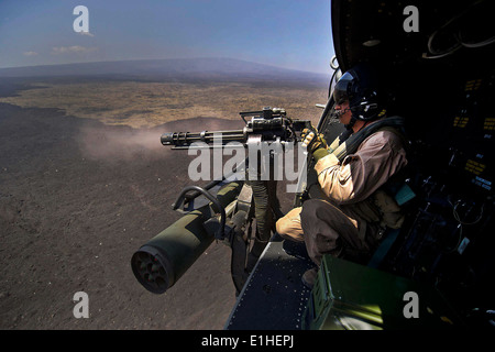 U.S. Marine Corps CPL. Richard Sippl, ein Flug-Crew-Chief zugewiesen, Marine Licht Angriff Hubschrauber Geschwader (HMLA) 169, feuert Stockfoto