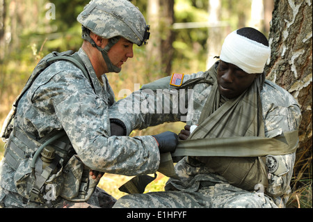 US Army Staff Sgt Devin Allred, links, bis zum 21. zugewiesen Theater Sustainment Command, behandelt einen simulierten Unfall während U Stockfoto