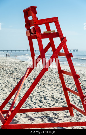 Am frühen Morgen Tragegurte Fisch, schlendern und Surfen über die leere Rettungsschwimmer Stand in Jacksonville Beach, Florida, USA. Stockfoto