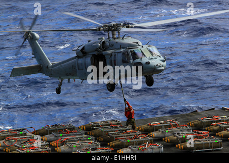 US-Seeleute an Bord des Flugzeugträgers USS Enterprise (CVN-65) legen Paletten von Munition auf einem MH-60 s Knighthawk helicopte Stockfoto