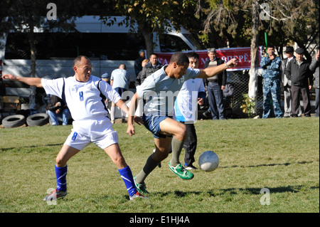 Rechts, bewegt sich Staff Sgt Kevin Ferguson den Ball vorbei ein Verteidiger während eines Fußballspiels 20. Oktober 2012, in Bischkek Polizei Acad Stockfoto