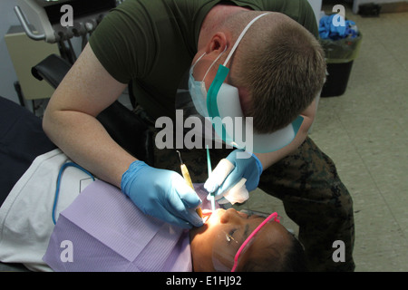 Ein Kind erhält eine zahnärztliche Versorgung von U.S. Marine Seemann Jeffrey M. Ker, eine mündliche chirurgischen Techniker mit der 11. Dental-Firma, 3r Stockfoto