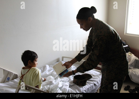 CPL. Tasia Wise liest ein Buch mit einem Kind im pädiatrischen Zentrum in Guam Memorial Hospital 6. Dez. während Übung Forager Fury Stockfoto