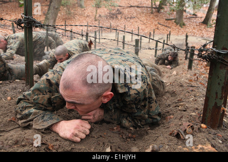 Ein Offizier-Kandidat von Officer Candidate School (OCS) niedrig kriecht unter einem Stacheldraht Hindernis auf die Montford Point Chal Stockfoto