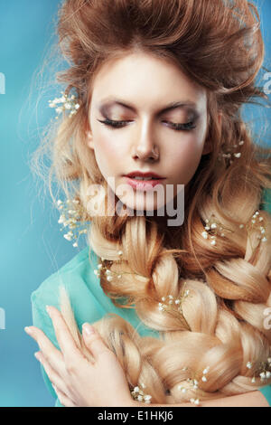 Genuss. Frau mit Zopf und ineinander verschlungenen Blumen Stockfoto