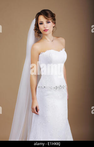Attraktive Braut im weißen Kleid und Schleier Stockfoto