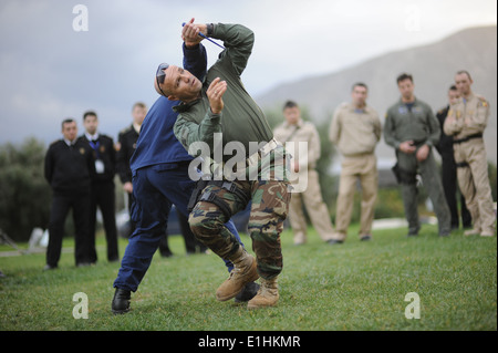 Durchführung von hellenischen Marine Ensign Alexander Tsaltas, rechts, und US Küstenwache CMdR Adam Chamie, links, Selbstverteidigung Training duri Stockfoto