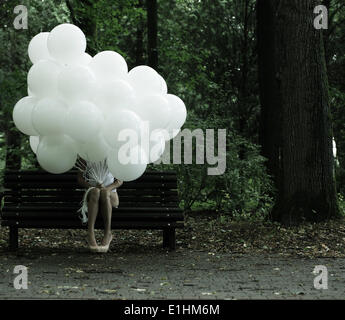 Sentimentalität. Nostalgie. Einsame Frau mit Luftballons auf Bank im Park sitzen Stockfoto