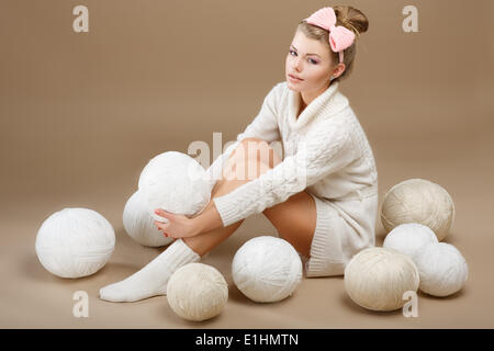 Häkeln. Schöne Handnäherin sitzen mit Haufen von weißen Stränge Garn. Needlecraft Stockfoto