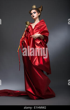 Im Mittelalter. Magie. Herrischer Frau Assistenten in roten Pallium mit Zepter. Hexerei Stockfoto