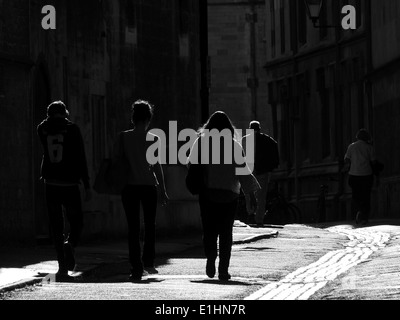 Silhouette Menschen auf eine teilweise gepflasterten Straße in Oxford in heller Sonne Stockfoto