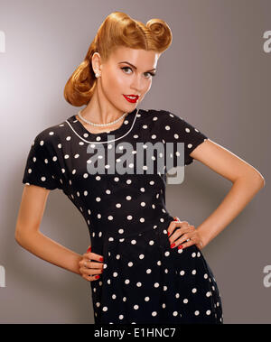 Romantik. Frau in blau Retro Polka Dot Kleid gestylt. Pin Up Stil Stockfoto