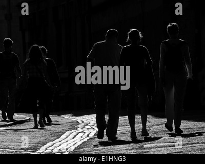 Silhouette Menschen auf eine teilweise gepflasterten Straße in Oxford in heller Sonne Stockfoto