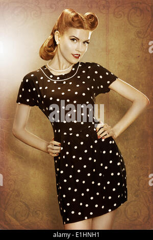 Pin-up-Girl in klassischer Mode Kleid Polka Dots posieren - Grunge Stockfoto