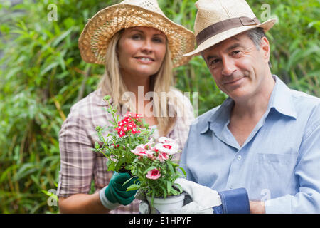 Blonde Frau und Mann, hält Topfpflanze Stockfoto